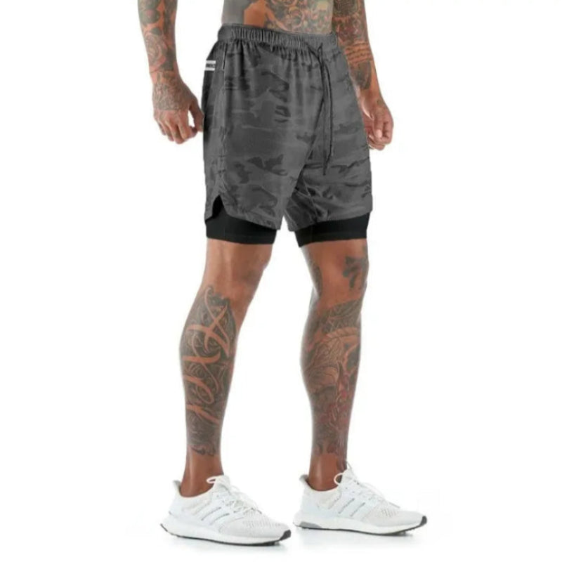 Person wearing gray camouflage shorts on a white background