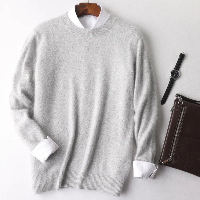Gray sweater with white cuffs and collar on a hanger, with a watch and brown leather pouch on a white background.