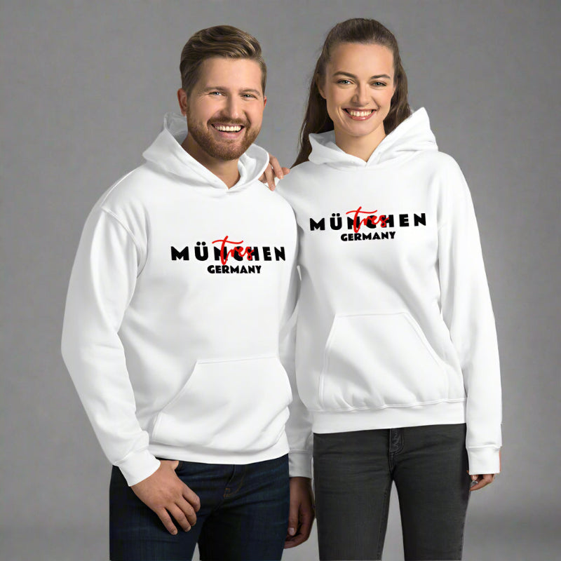 A man and a woman smiling and wearing white hoodies with red and black text on the front.