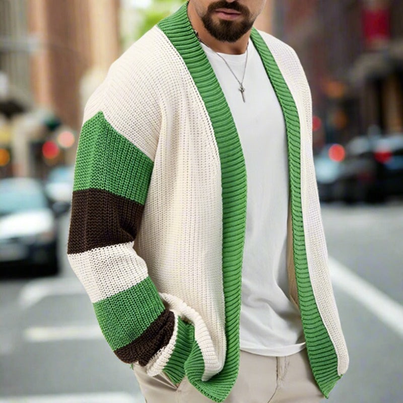 Man wearing a green and beige cardigan on a city street.