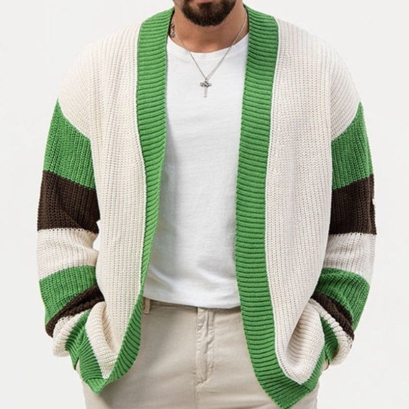 Man wearing a green and white cardigan with a white shirt underneath on a white background