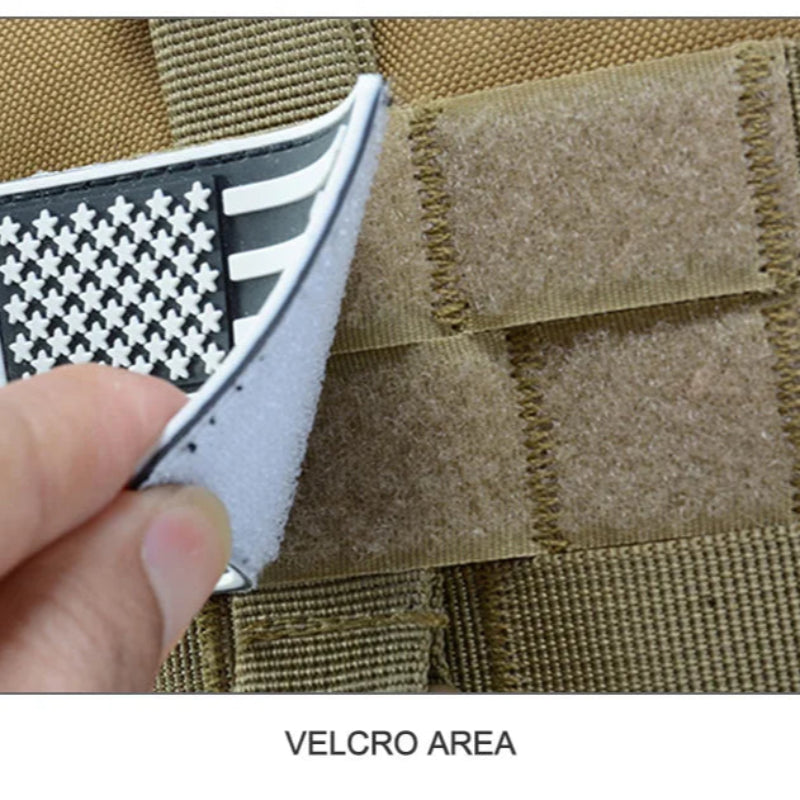 Hand applying a patch with an American flag design to a brown tactical vest.