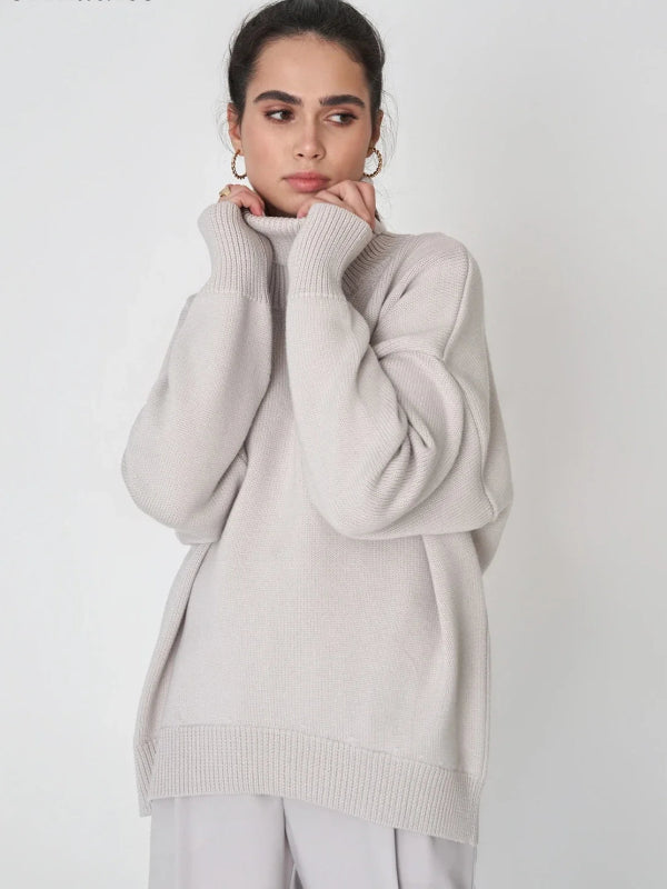 Woman wearing a light gray sweater with a plain background, branded 'Bornladies'.