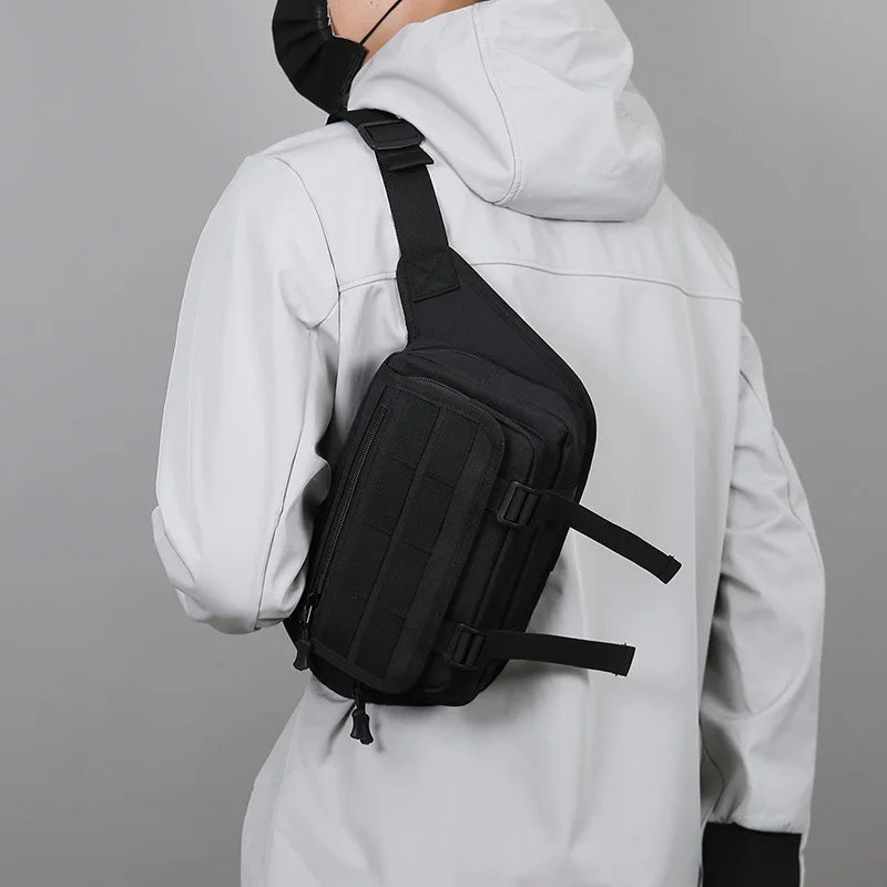 Person wearing a black sling bag over one shoulder against a gray background