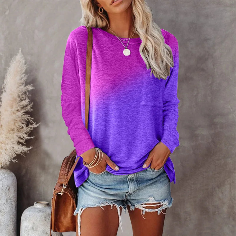 Woman wearing a purple long-sleeve top and denim shorts, standing against a neutral background.