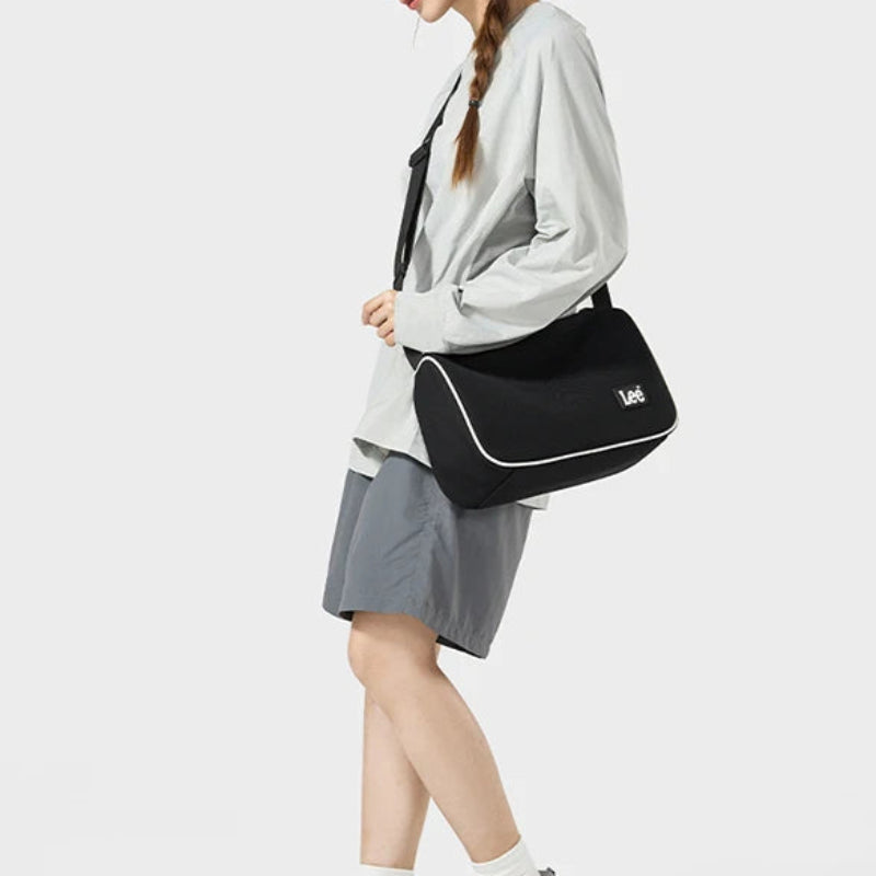 Woman carrying a black crossbody bag on a white background