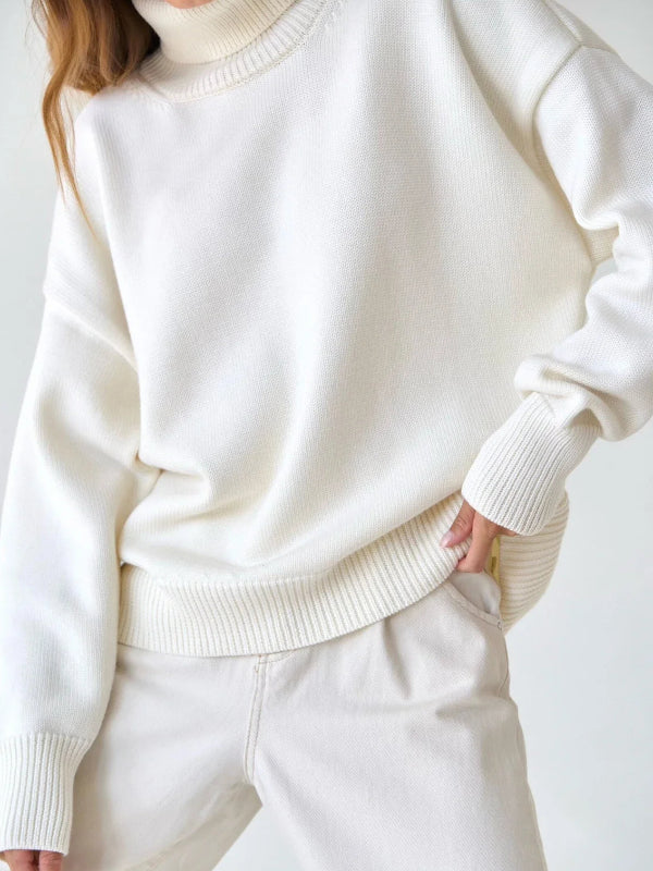 Person wearing a white sweater and pants on a plain background