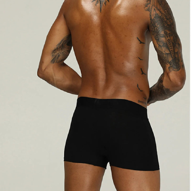 Man wearing black underwear with a neutral background