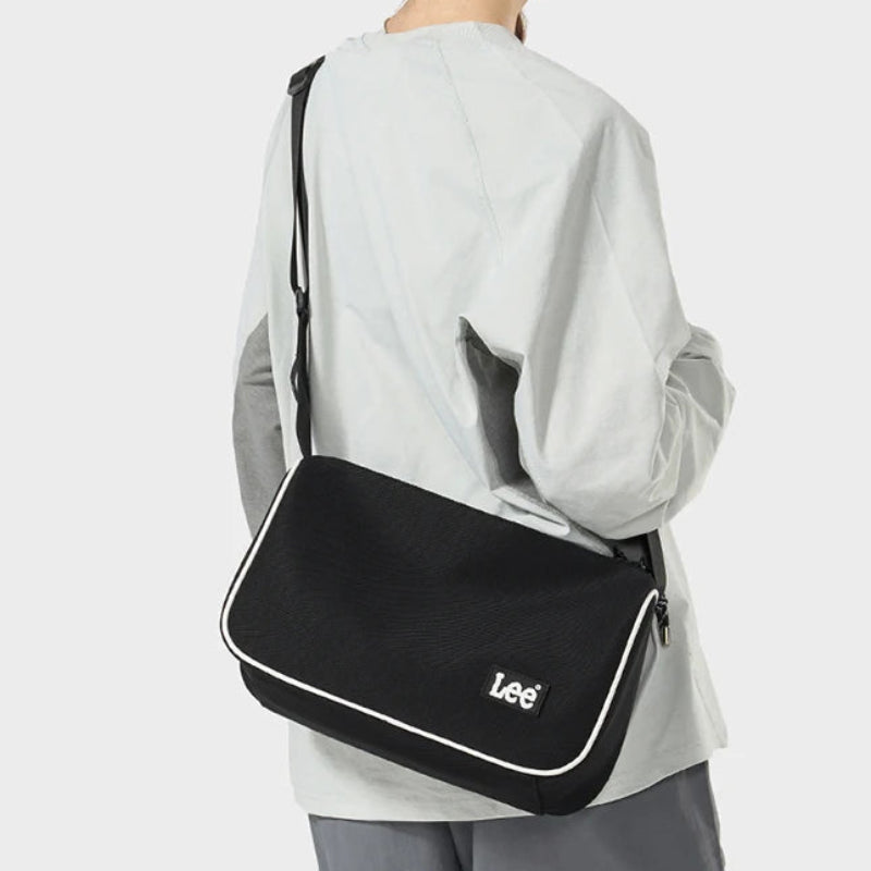Person wearing a black shoulder bag with 'Lee' branding on a white background